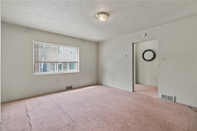 carpeted spare room featuring a textured ceiling