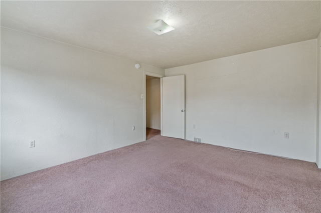 carpeted spare room featuring a textured ceiling