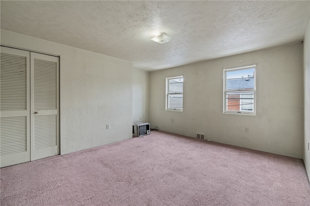 empty room featuring carpet floors and a textured ceiling