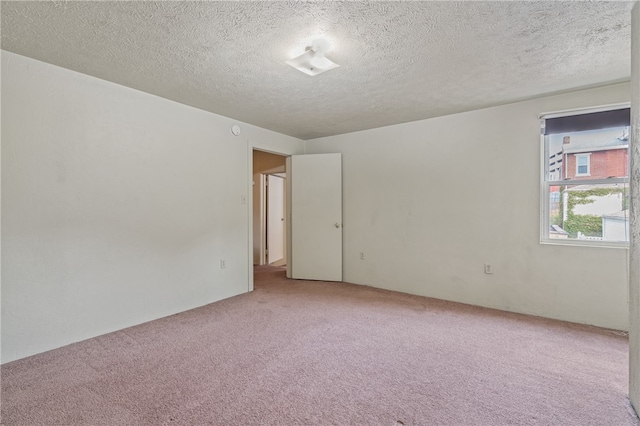 carpeted empty room with a textured ceiling