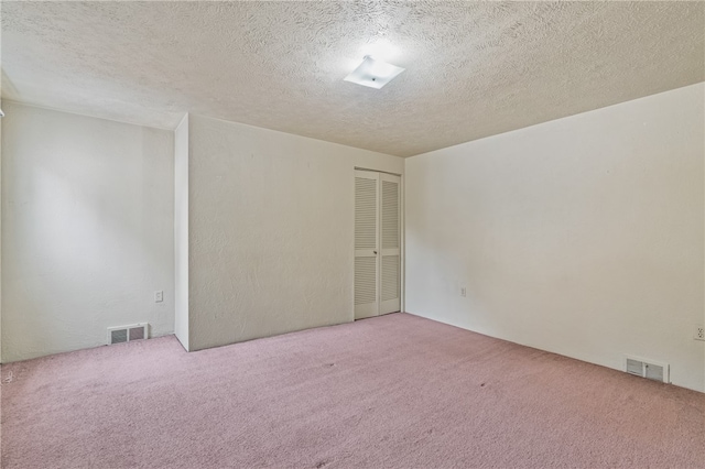 carpeted spare room with a textured ceiling