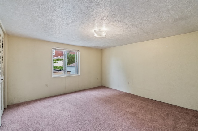 unfurnished room featuring a textured ceiling and carpet flooring