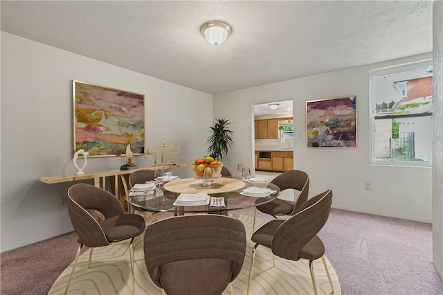 dining area with light carpet and a textured ceiling