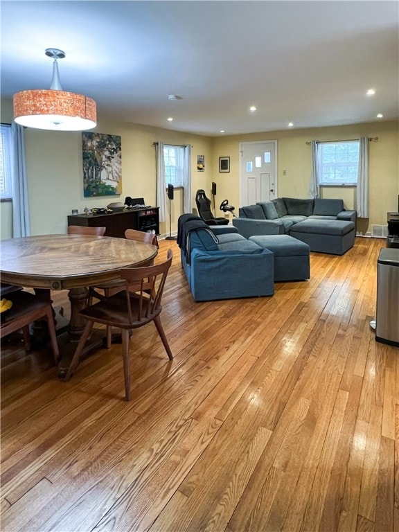 dining room with light wood-type flooring and a healthy amount of sunlight