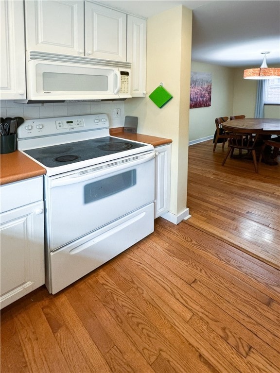 kitchen with light wood-type flooring, white appliances, and white cabinets