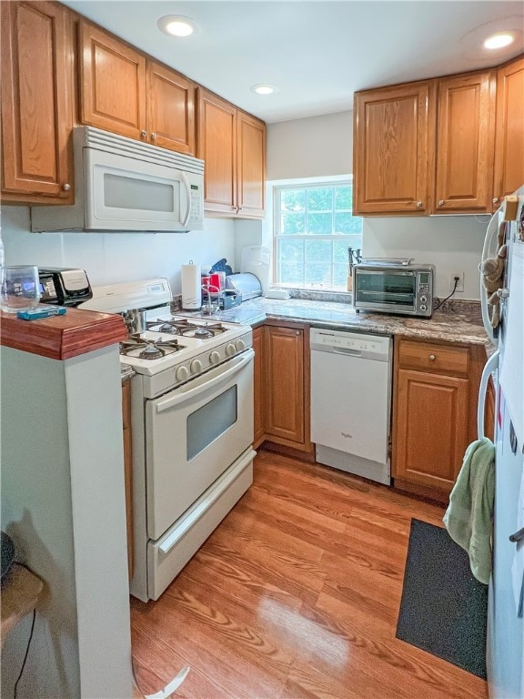 kitchen with light hardwood / wood-style floors and white appliances