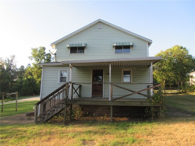 rear view of property with a porch and a lawn