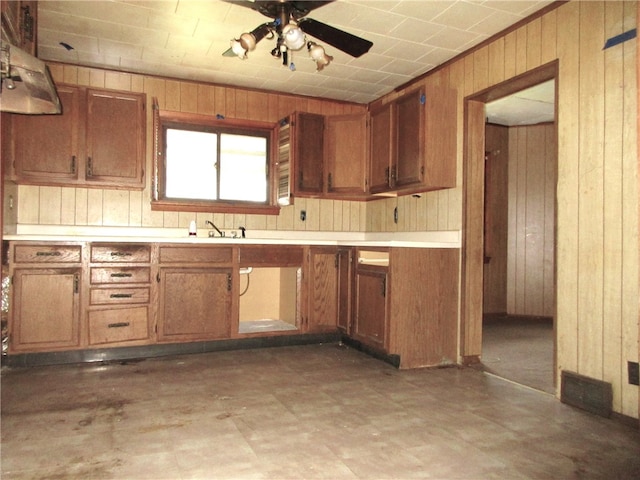 kitchen featuring wood walls and ceiling fan