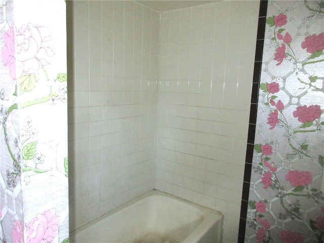 bathroom with a wealth of natural light and tiled shower / bath combo