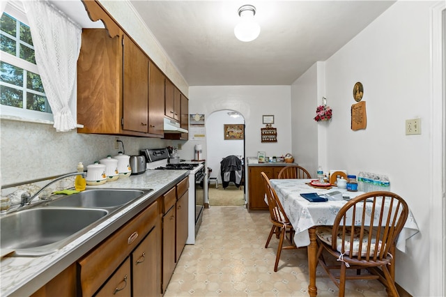 kitchen featuring white stove and sink