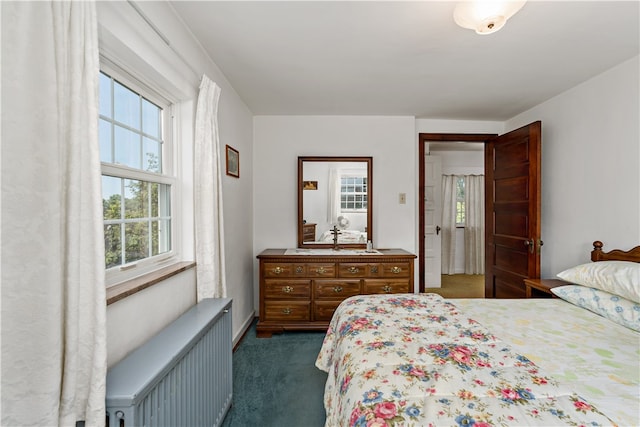 bedroom with dark carpet and radiator heating unit