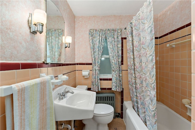 full bathroom with tile patterned flooring, radiator heating unit, shower / bath combo with shower curtain, tile walls, and toilet