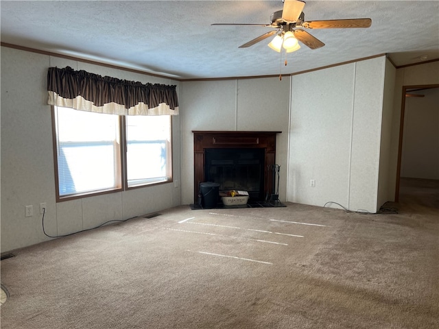 unfurnished living room with ceiling fan, a textured ceiling, carpet floors, and crown molding