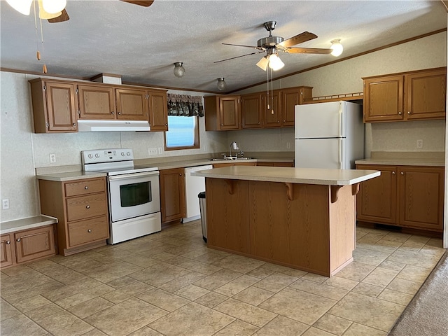 kitchen featuring white appliances, a kitchen island, a textured ceiling, crown molding, and ceiling fan