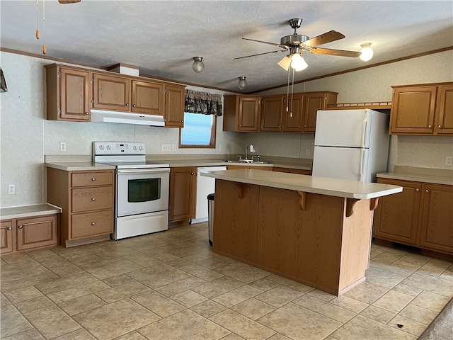 kitchen with ceiling fan, white appliances, a kitchen island, a textured ceiling, and crown molding