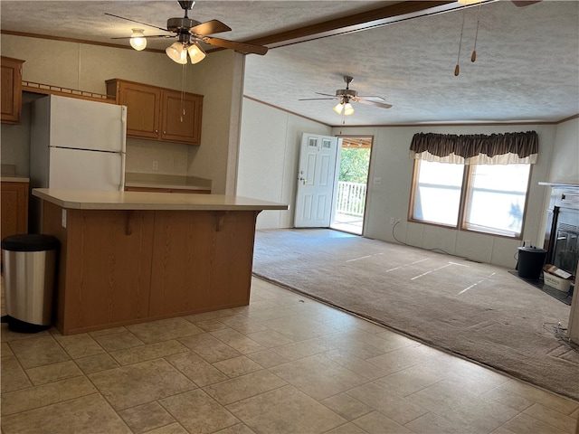 kitchen with light carpet, ceiling fan, white fridge, and a textured ceiling