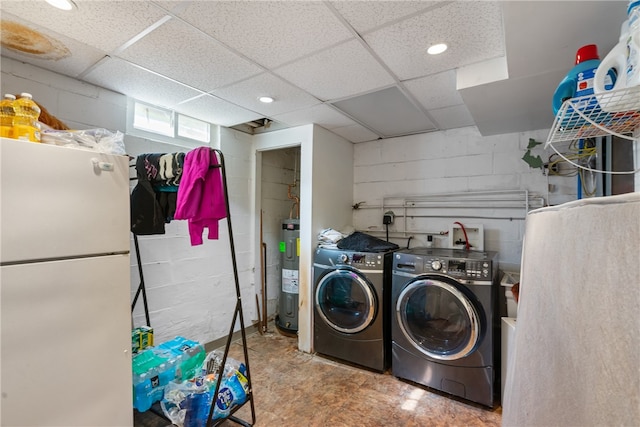 clothes washing area featuring electric water heater and independent washer and dryer