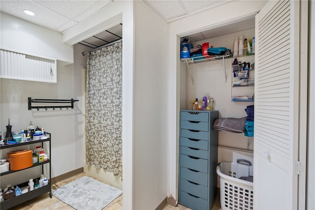 bathroom with a drop ceiling and a bath