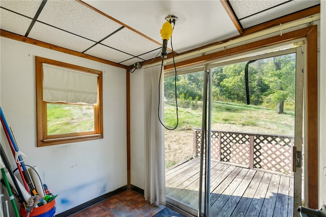 doorway to outside featuring dark parquet floors and a paneled ceiling