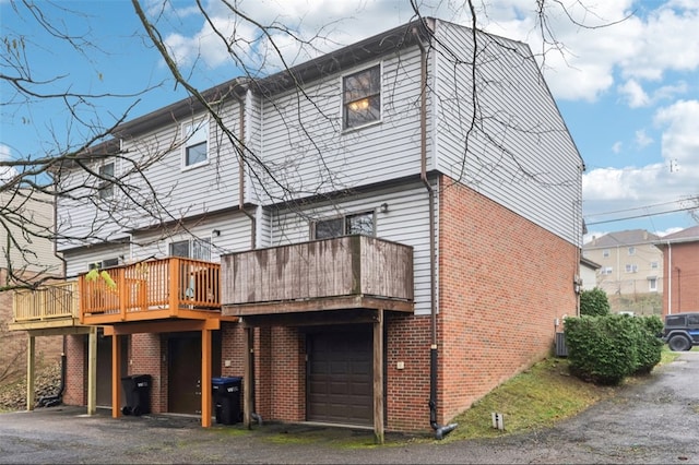 back of property with a garage and a deck