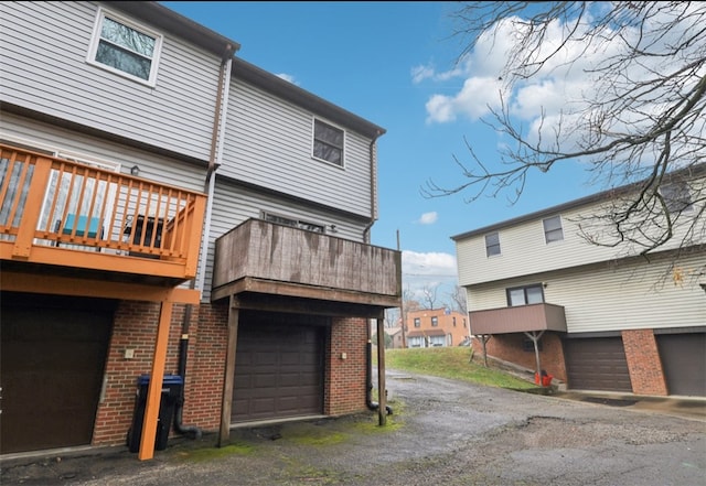 rear view of house featuring a balcony and a garage