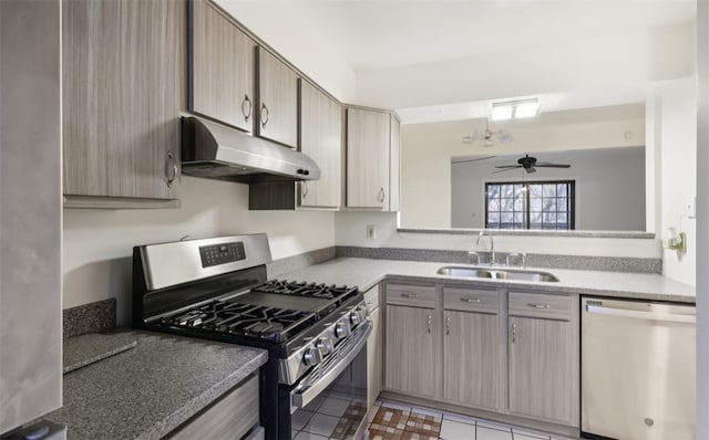 kitchen with ceiling fan, sink, stainless steel appliances, and dark tile patterned flooring