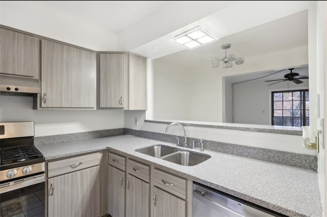 kitchen featuring sink, stainless steel appliances, kitchen peninsula, light brown cabinetry, and ceiling fan with notable chandelier