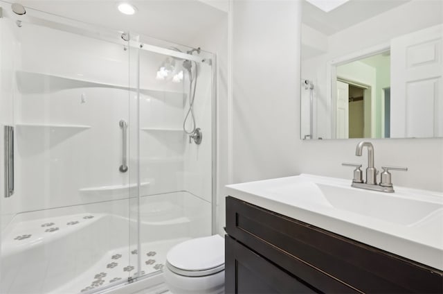 bathroom featuring vanity, toilet, and a shower with shower door