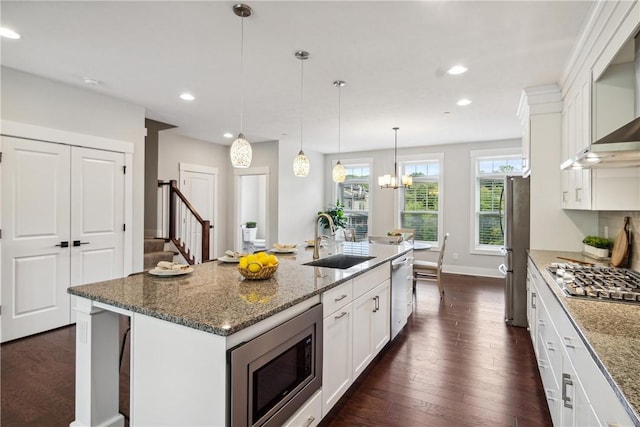 kitchen featuring white cabinetry, a center island with sink, stainless steel appliances, and sink