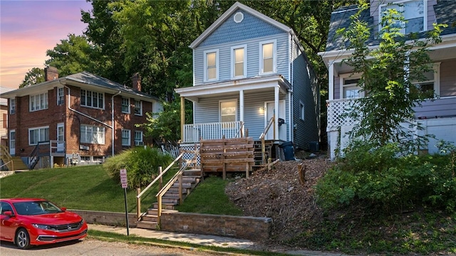 view of front of home with a lawn and a porch