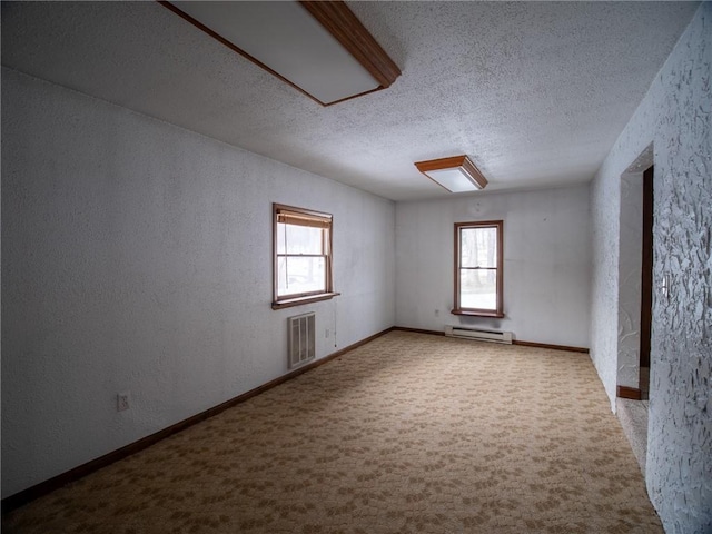 carpeted empty room with a baseboard radiator and a textured ceiling