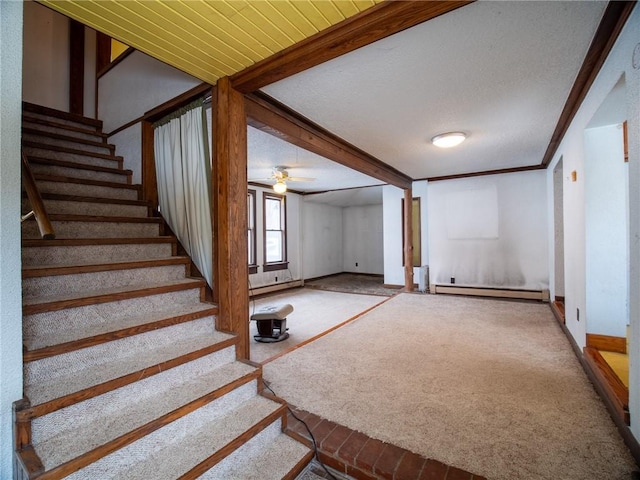 interior space with crown molding, ceiling fan, baseboard heating, beam ceiling, and carpet flooring