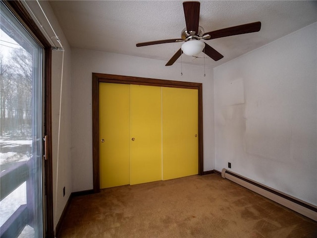 unfurnished bedroom with carpet flooring, a baseboard heating unit, ceiling fan, a textured ceiling, and a closet