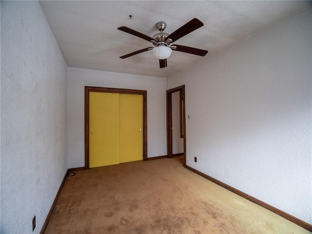 unfurnished bedroom featuring carpet flooring, ceiling fan, and a closet