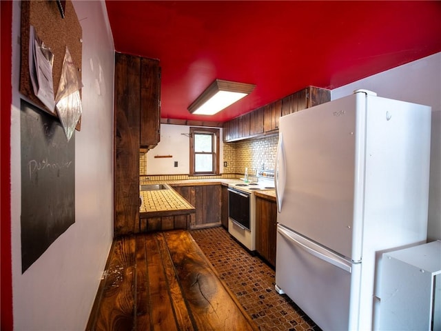 kitchen with dark wood-type flooring, white appliances, and backsplash