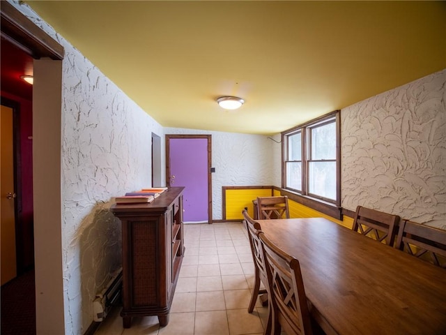 tiled dining space with a baseboard heating unit