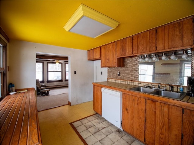 kitchen featuring white dishwasher, sink, and backsplash