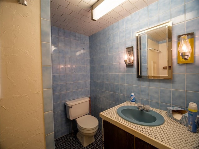 bathroom with tile patterned flooring, vanity, tile walls, and toilet