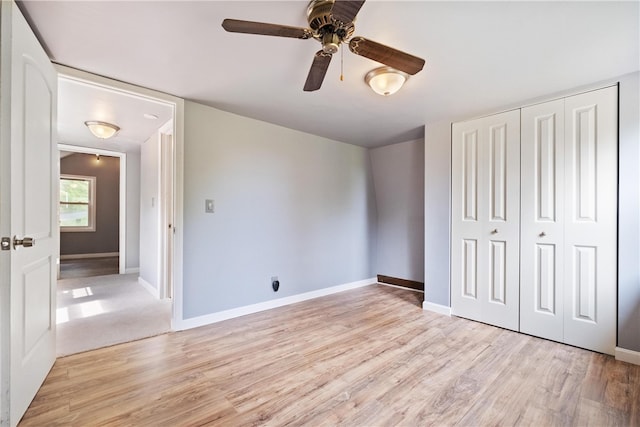 unfurnished bedroom with ceiling fan, a closet, and light wood-type flooring