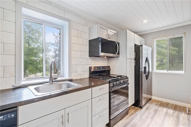 kitchen with crown molding, sink, light hardwood / wood-style flooring, appliances with stainless steel finishes, and white cabinetry