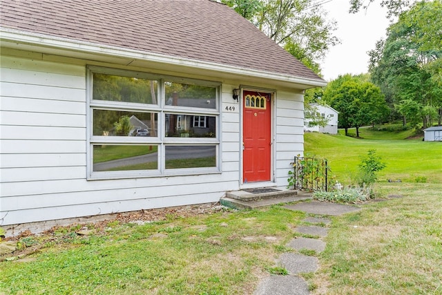 view of exterior entry with a lawn