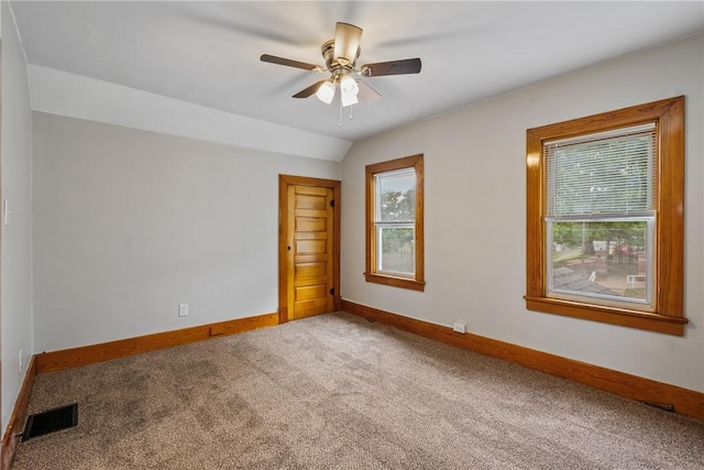 spare room featuring carpet floors, a healthy amount of sunlight, and vaulted ceiling