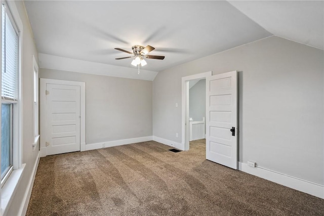 interior space featuring ceiling fan, lofted ceiling, and carpet floors