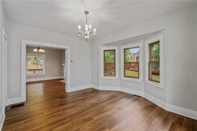 unfurnished room featuring dark wood-type flooring and a chandelier