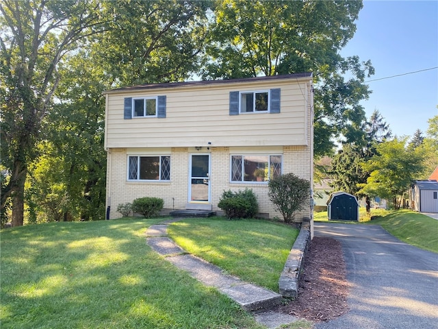 view of front facade featuring a storage shed and a front lawn