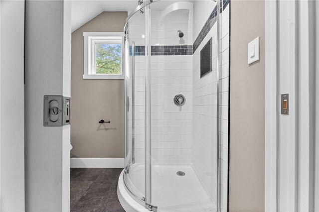 bathroom featuring lofted ceiling, walk in shower, and tile patterned floors