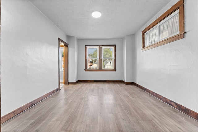 spare room featuring a textured ceiling and light wood-type flooring