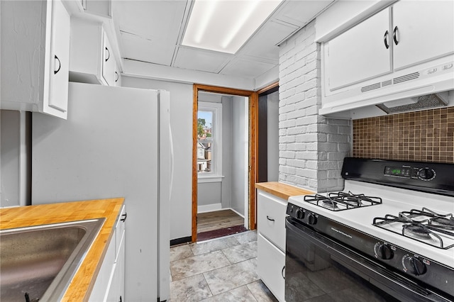 kitchen with tasteful backsplash, sink, white cabinets, wooden counters, and gas range