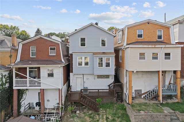 rear view of house featuring a wooden deck