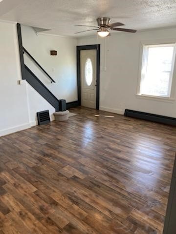 entrance foyer featuring a baseboard heating unit, ceiling fan, a textured ceiling, and dark hardwood / wood-style flooring